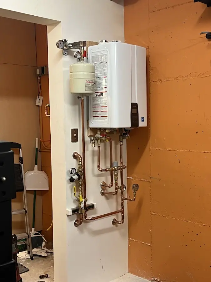 Plumbing technician inspecting water heater connections in La Crosse